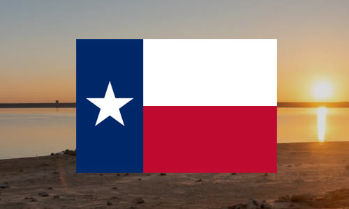 Texas state flag over a lake at sunset