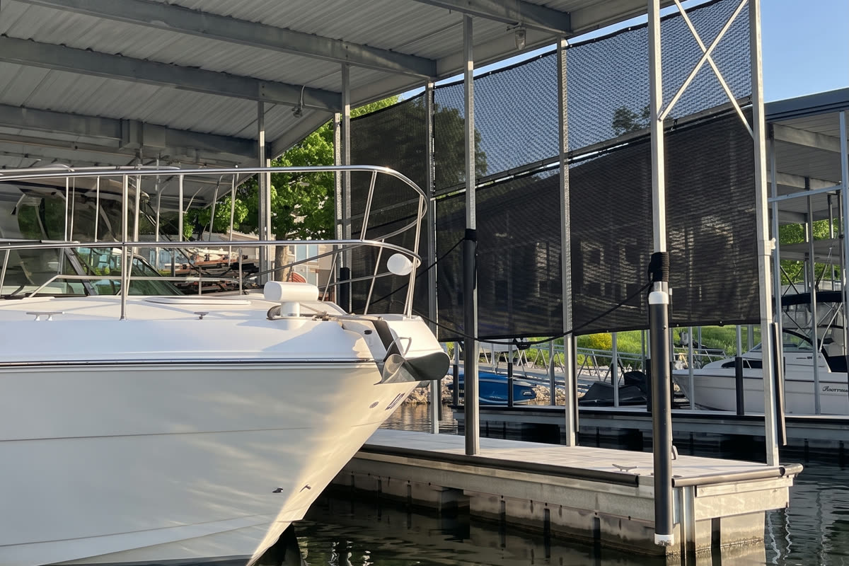 Tensioned spider netting enclosing a boat slip, holding steady in open weather