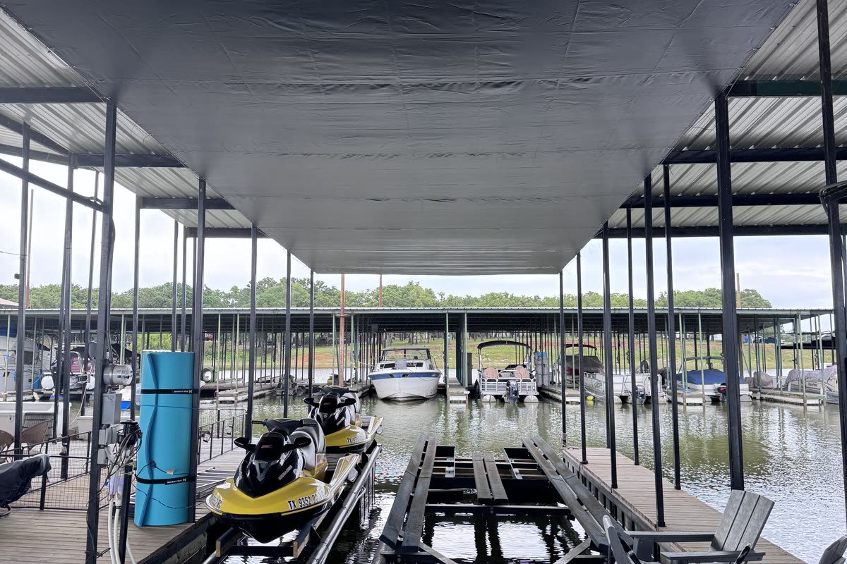 Covered slip with jet ski lift and boats protected under one netting canopy